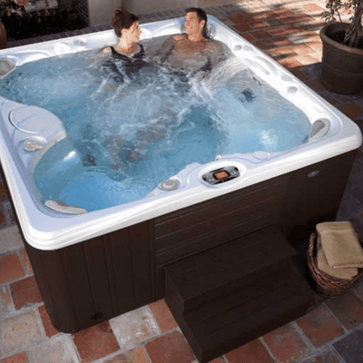 couple profitant du spa Caldera Salina Série Paradise en extérieur avec hydromassage actif