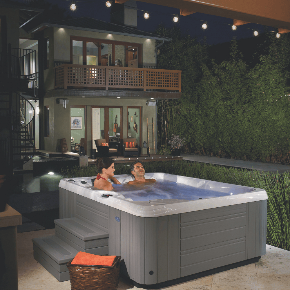 spa Caldera Paradise Kauai 3 places installe en terrasse de nuit avec couple en relaxation eau chaude jets en fonctionnement