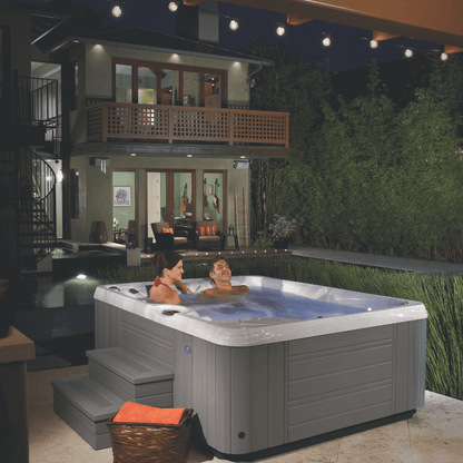 spa Caldera Paradise Kauai 3 places installe en terrasse de nuit avec couple en relaxation eau chaude jets en fonctionnement