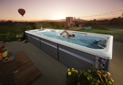 nageur utilisant le courant de nage du spa de nage Endless Pools E2000 sur terrasse au coucher du soleil