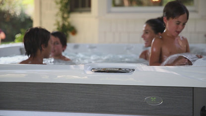 famille utilisant le spa Caldera Reunion Serie Paradise avec jets hydromassage en fonctionnement en environnement exterieur